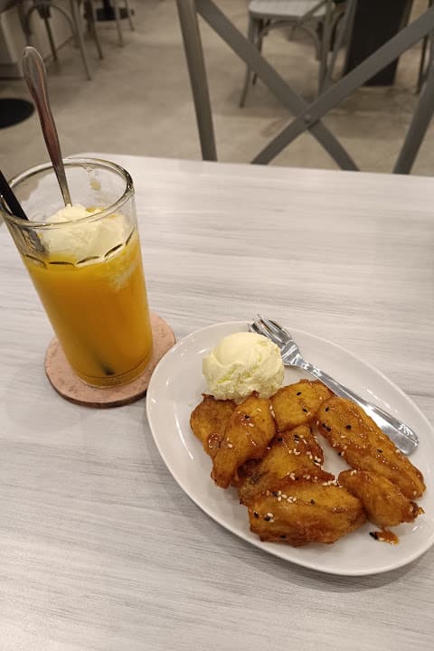 Gorengan pisang bersaus karamel dengan sekop es krim vanila dan es teh mangga